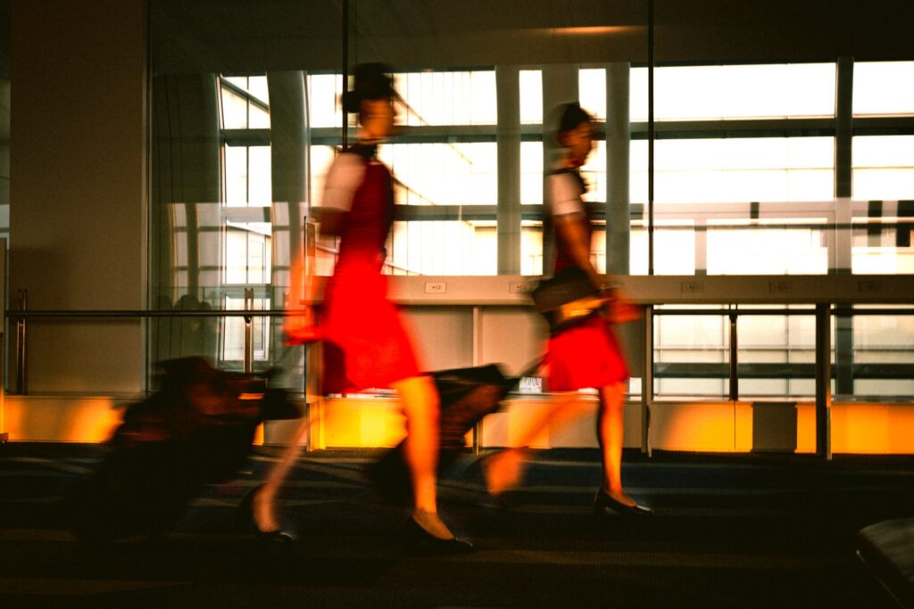 Two flight attendants are walking in the airport.